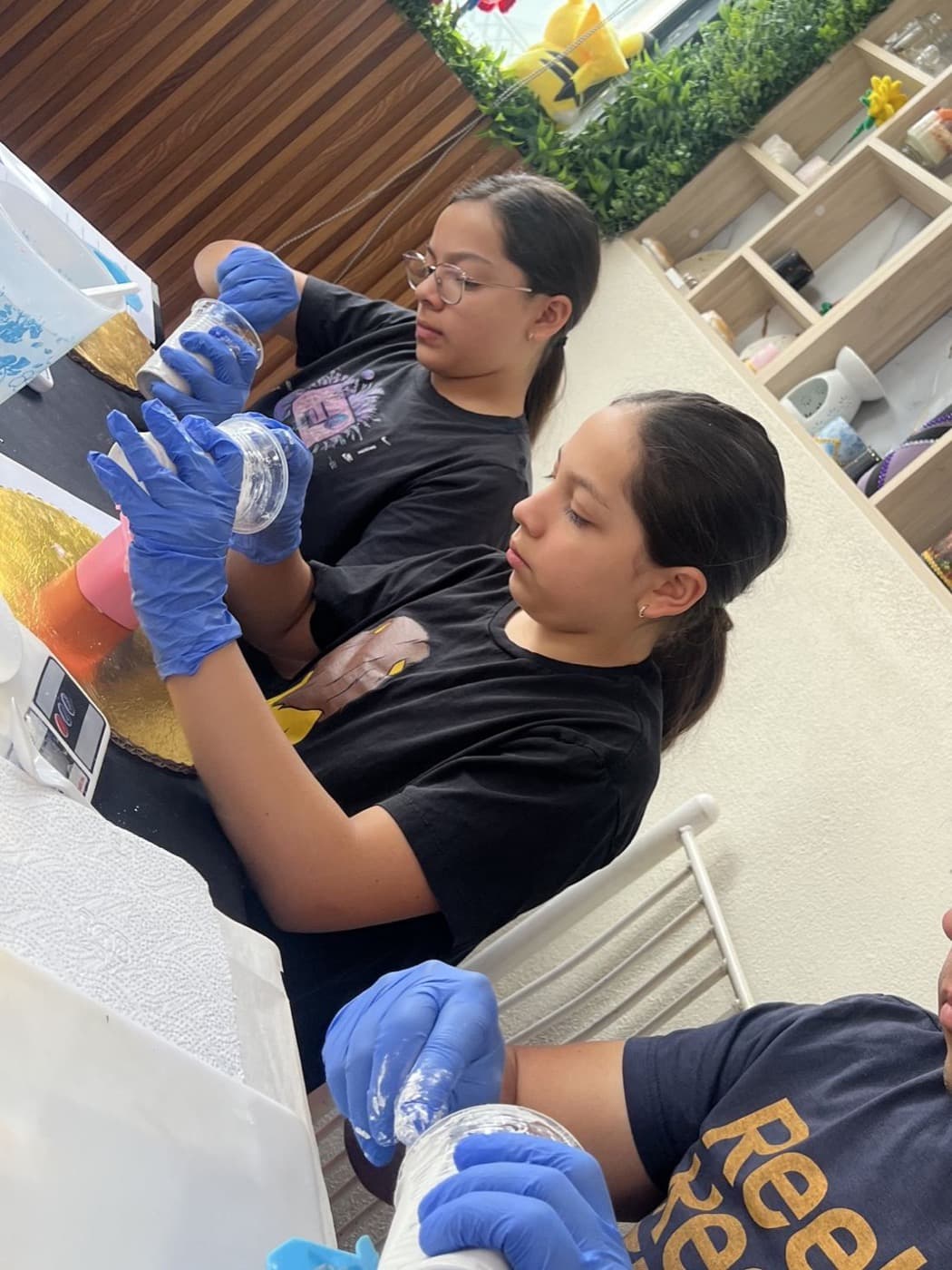 Emi y Abi hoy, con guantes, haciendo un experimento de ciencias